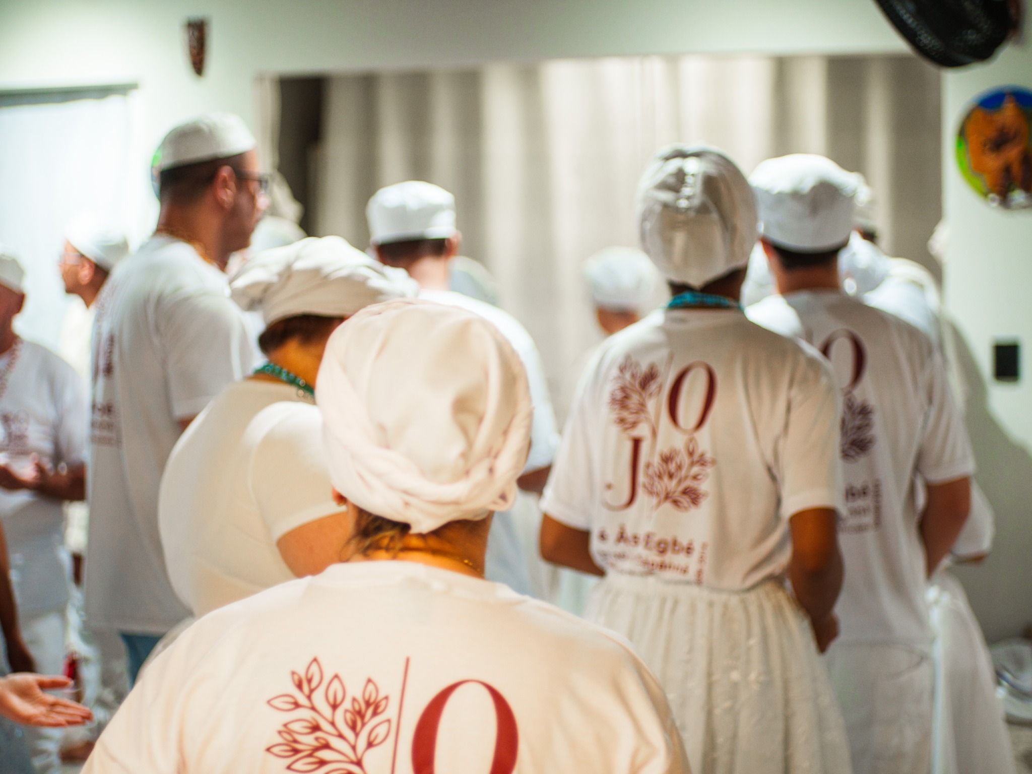 Integrantes do Reino reunidos durante uma celebração, vestidos de branco